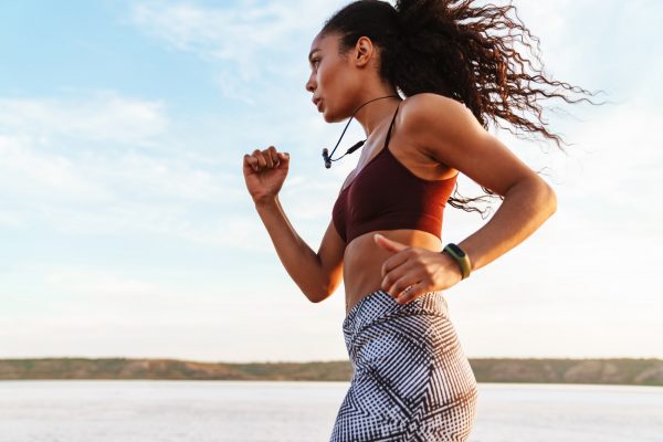 African american sports woman running on the beach
