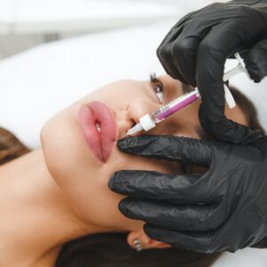 female lips, lip augmentation procedure. A syringe near a woman's mouth, injections to increase